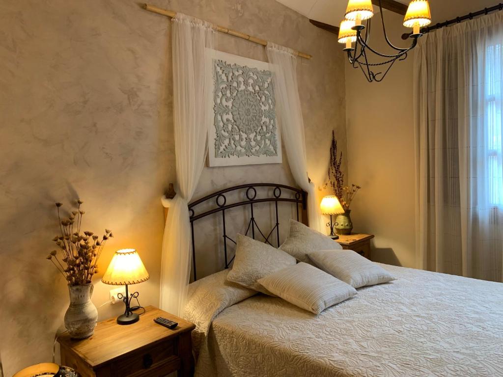 a bedroom with a bed with two lamps and a window at Casa Rural Valle del Palancia in Castellnovo