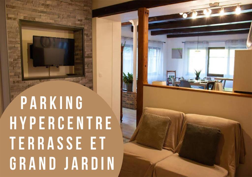 a living room with a couch and a tv at Le gîte du chateau dans le centre de schirmeck in Schirmeck