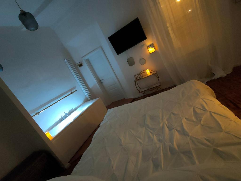 a white bedroom with a bed and a window at Il Sitarein in Bologna