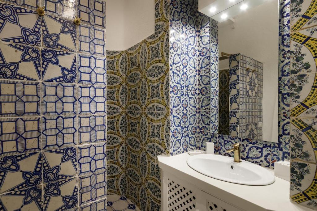 a bathroom with blue and white tiled walls and a sink at Qasar Luxury Suite - in Capri's Piazzetta in Capri