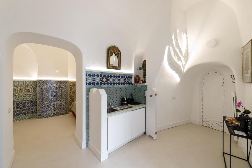 a kitchen with white walls and blue tiles at Qasar Luxury Suite - in Capri's Piazzetta in Capri