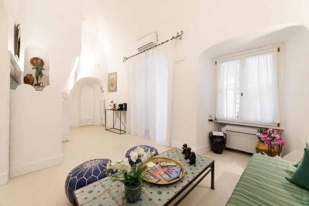 a living room with white walls and a table at Qasar Luxury Suite - in Capri's Piazzetta in Capri