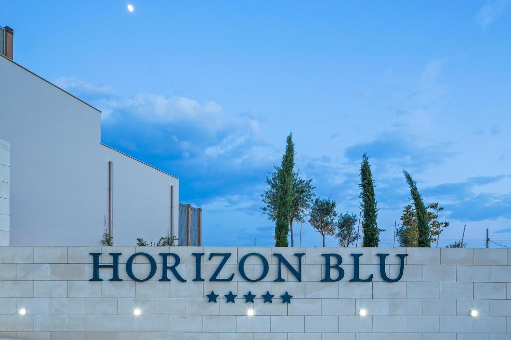 a sign for a hotel with a sign for horizon blyu at Horizon Blu Boutique Hotel in Kalamata