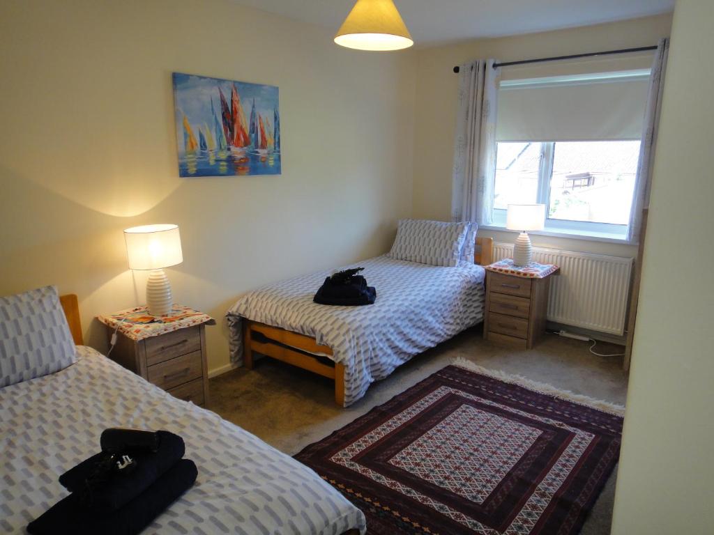 Zimmer mit 2 Betten, 2 Lampen und einem Fenster in der Unterkunft 6 Berth House, 2 Bthrm, 2 WC, Parking, Washer, Dryer in Corby