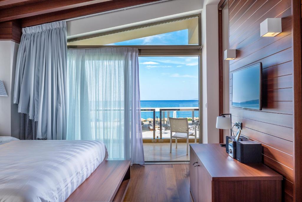 a bedroom with a bed and a view of the ocean at Horizon Blu Boutique Hotel in Kalamata