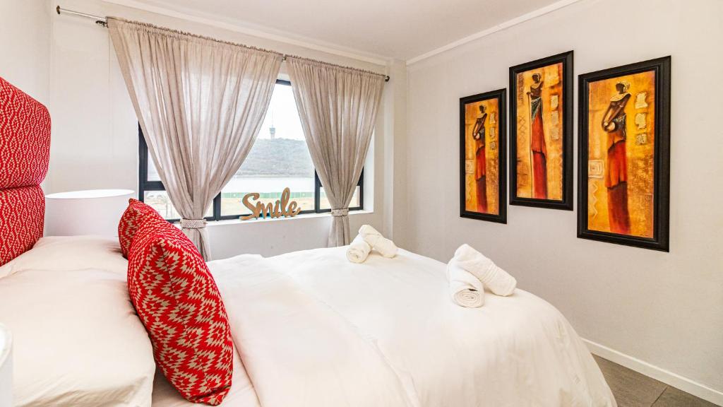a bedroom with a white bed and a window at East Point in Durban