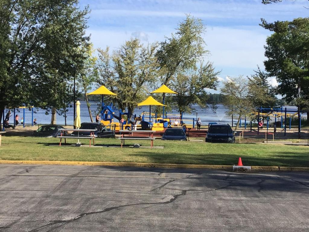 a park with tables and chairs and yellow umbrellas at Park Place Motel & Suites in Tweed