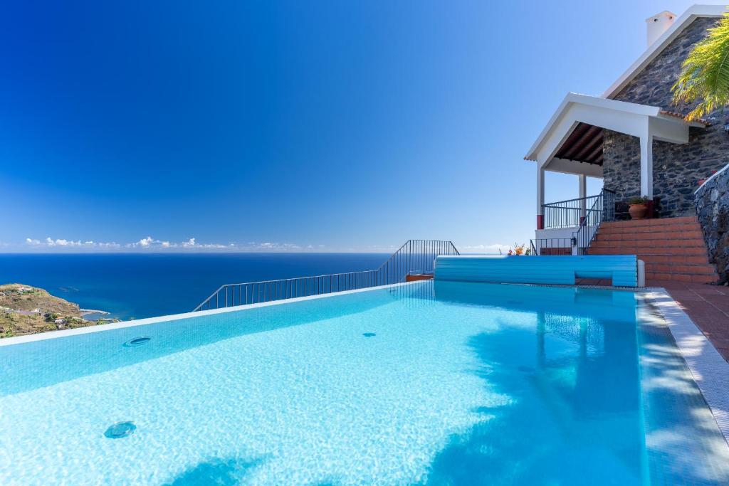 a swimming pool with a view of the ocean at Villa Tabua in Ribeira Brava