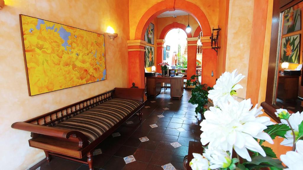 a hallway with a bench and flowers in a building at Casa Montalvo Bed & Breakfast in Cuenca