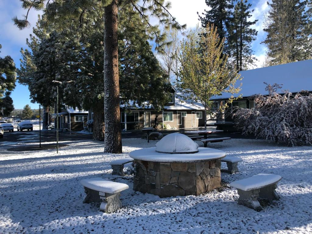 a picnic table and benches in a snow covered park at Bay Meadows Resort in Big Bear Lake