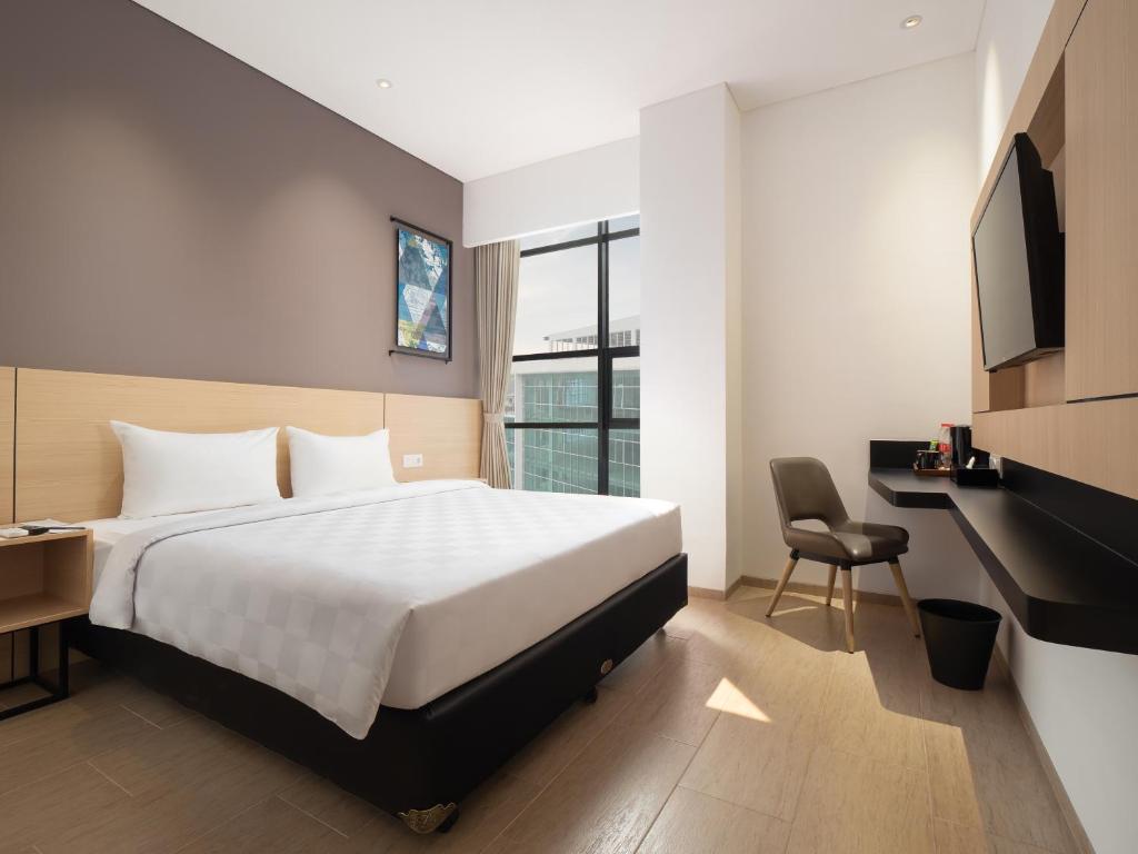 Säng eller sängar i ett rum på Hotel 88 Blok M Jakarta By WH