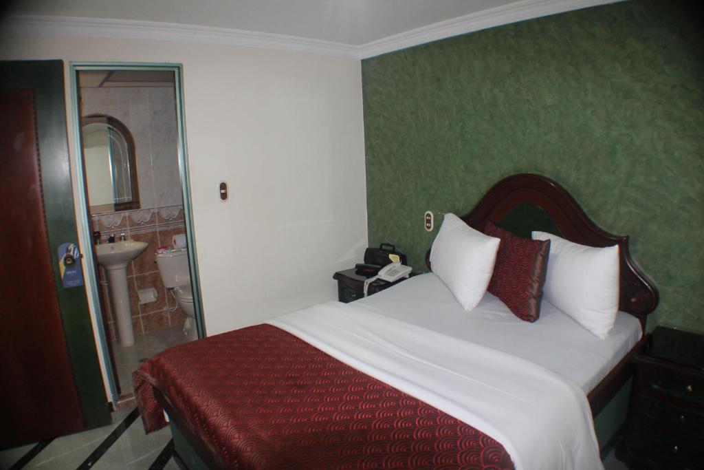 a hotel room with a bed and a bathroom at Lafont Park Hotel in Bogotá