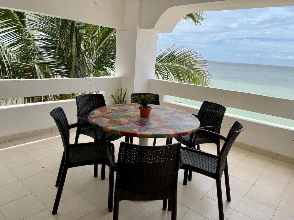 una mesa y sillas en un balcón con vistas al océano en Departamento Medina en Progreso