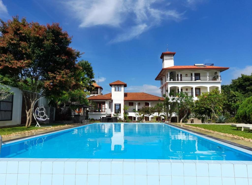 a large swimming pool in front of a house at Elegant Hotel in Kandy