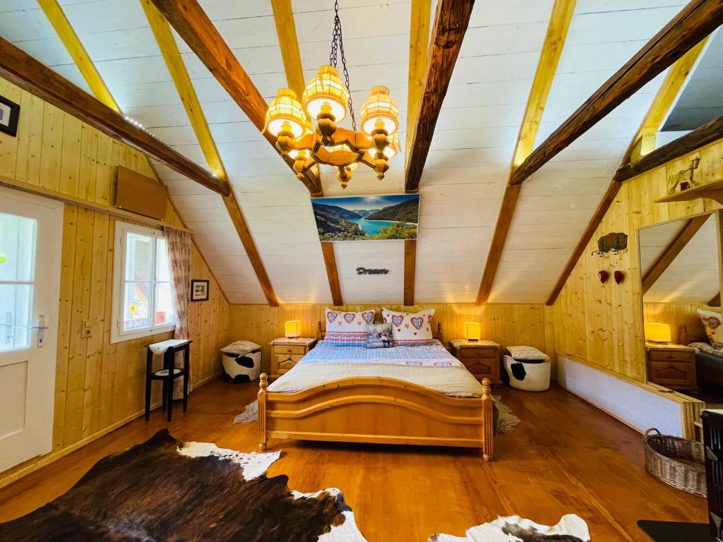 ein Schlafzimmer mit einem Bett und einer Decke mit einem Kronleuchter in der Unterkunft Chalet anno 1794 in Rettenegg