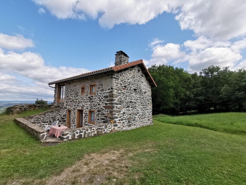 uma velha casa de pedra no topo de um campo em Gîte Retournac, 3 pièces, 4 personnes - FR-1-582-319 em Retournac