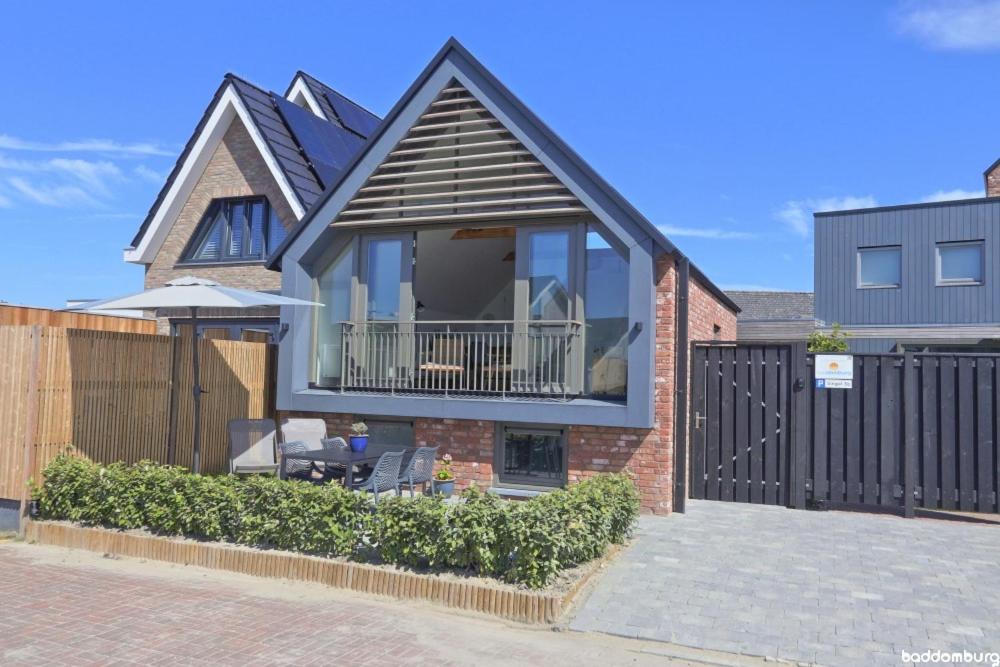 a house with a balcony with a fence at NIEUW! Vakantiehuis Singel 3A met SAUNA - baddomburg in Domburg