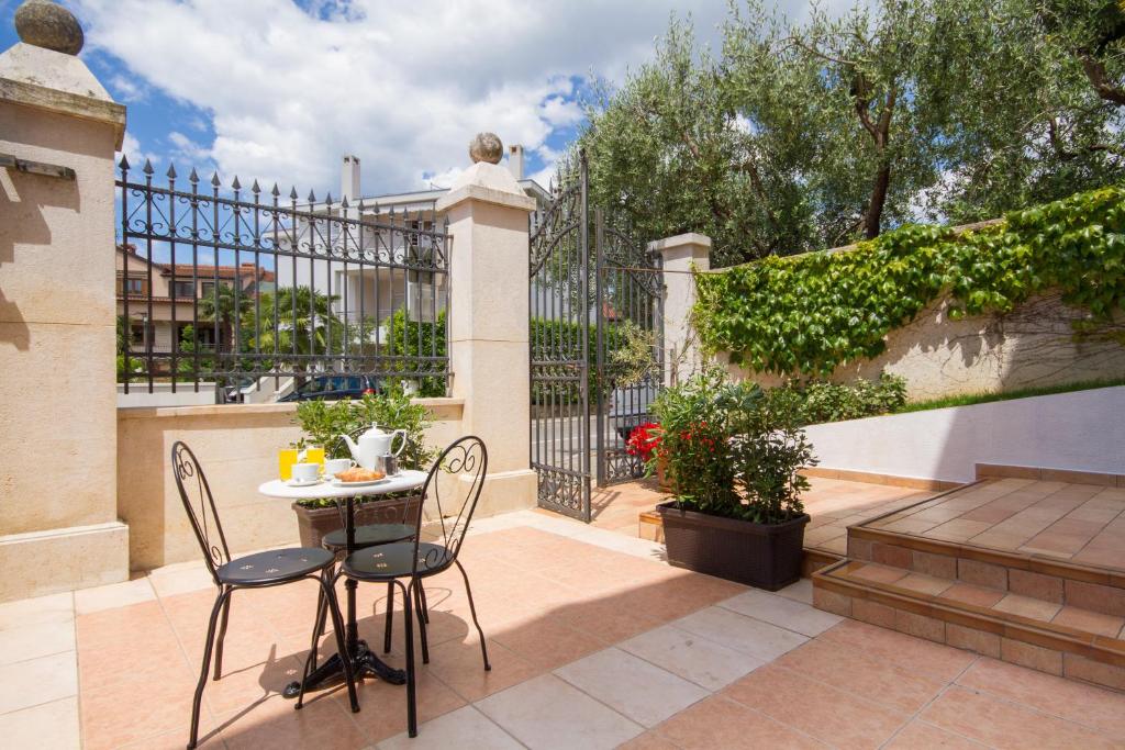 patio ze stołem, krzesłami i ogrodzeniem w obiekcie Villa Sveta Eufemija - Bed and breakfast w Rovinj