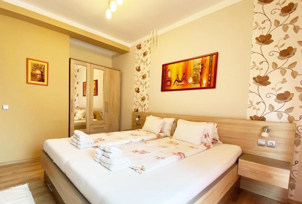 a hotel room with a large bed and a painting on the wall at Apartman Siesta Bük in Bük