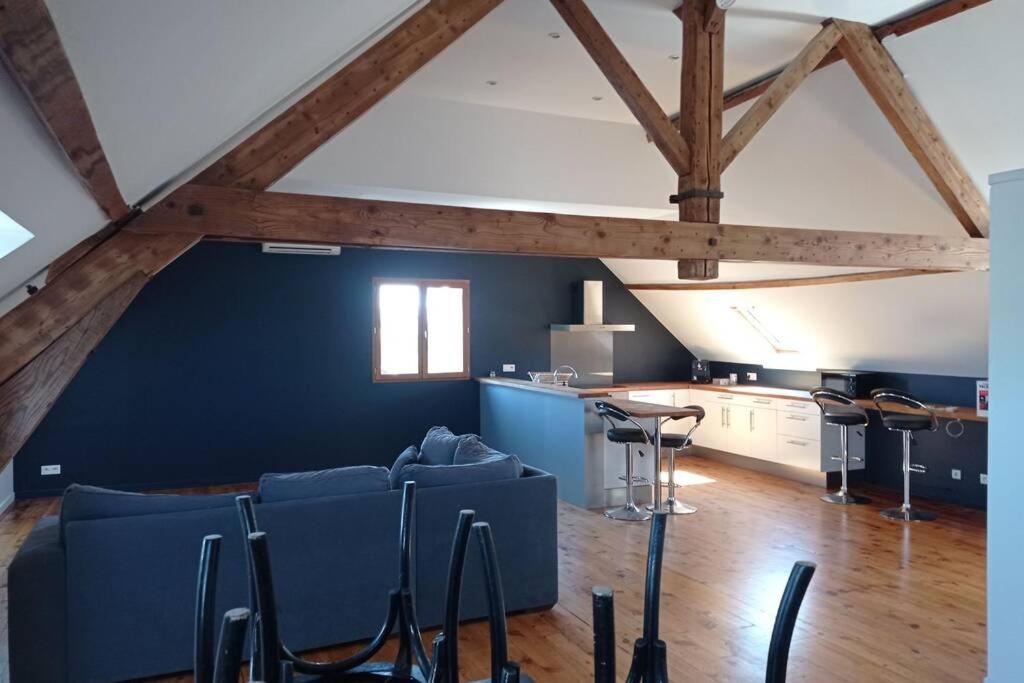 ein Wohnzimmer mit einem blauen Sofa und Stühlen in der Unterkunft Appartement moderne et lumineux in Brive-la-Gaillarde