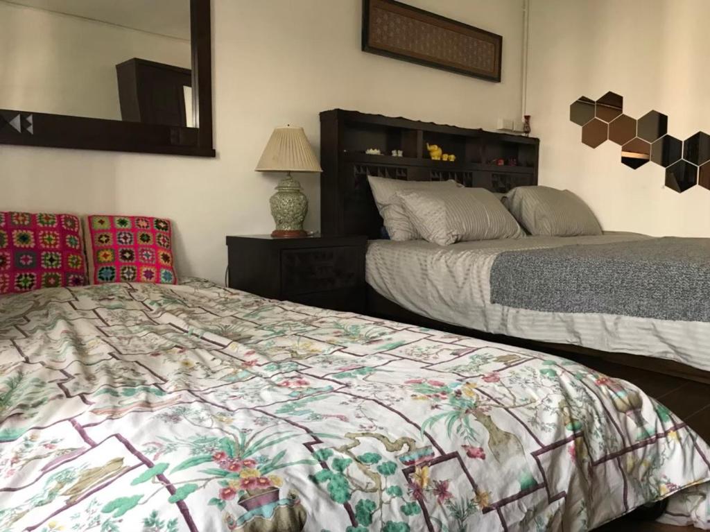 1 dormitorio con 2 camas y espejo en Kiang Mo Gumpuju en Chiang Mai