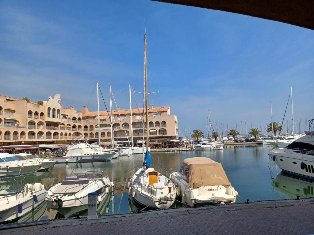 a group of boats docked in a marina with buildings at La Gavine studio vue mer in Hyères