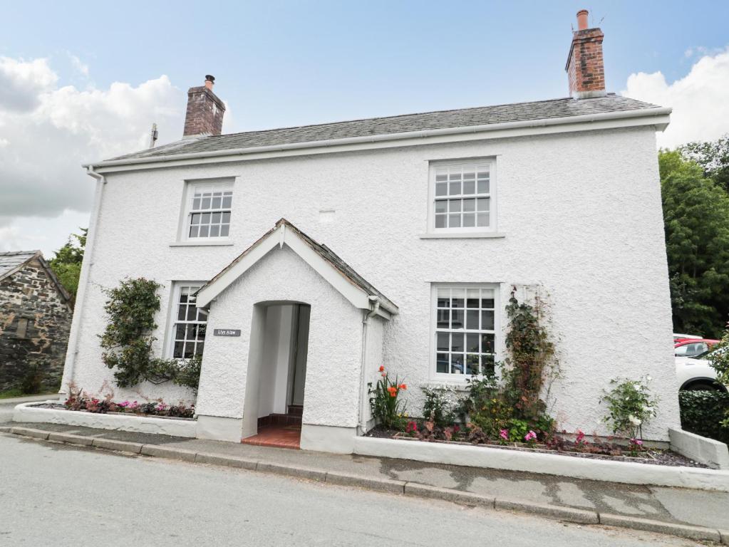 a white house with flowers in front of it at Llys Alaw in Abergele