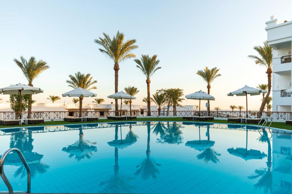 uma piscina com palmeiras e um hotel em Sunrise Remal Beach Resort em Sharm el Sheikh