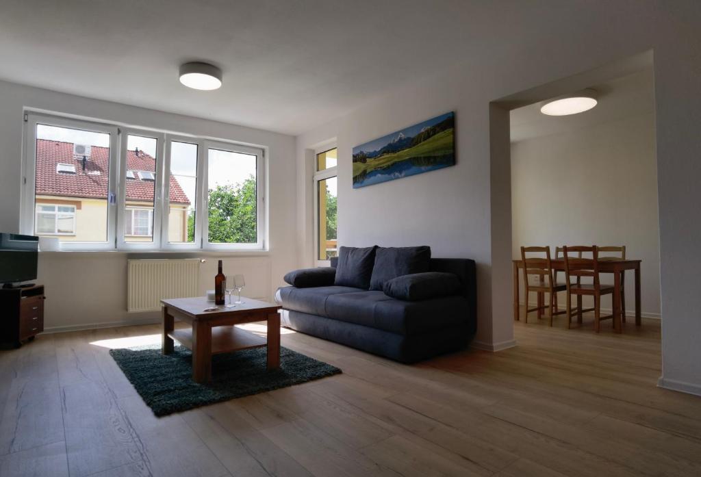 uma sala de estar com um sofá e uma mesa em Apartmán Športová em Trnava