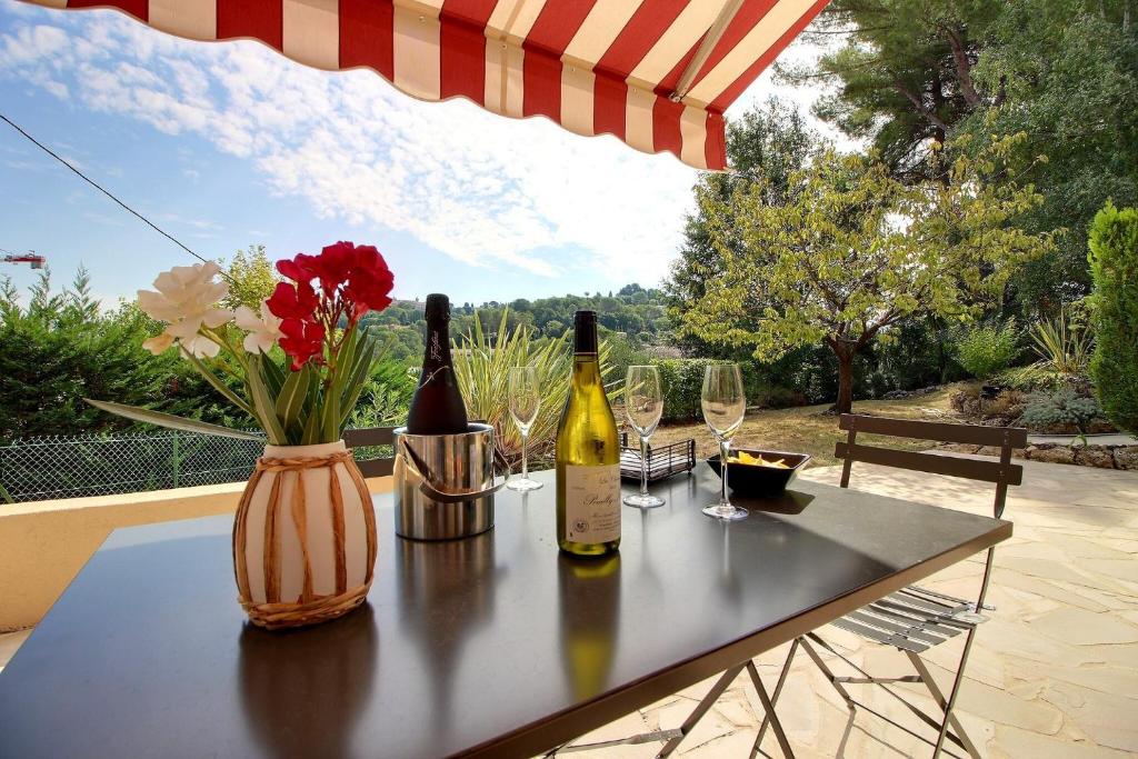 una mesa con 2 botellas de vino y copas de vino en Un havre de paix au cœur de Mougins, en Mougins