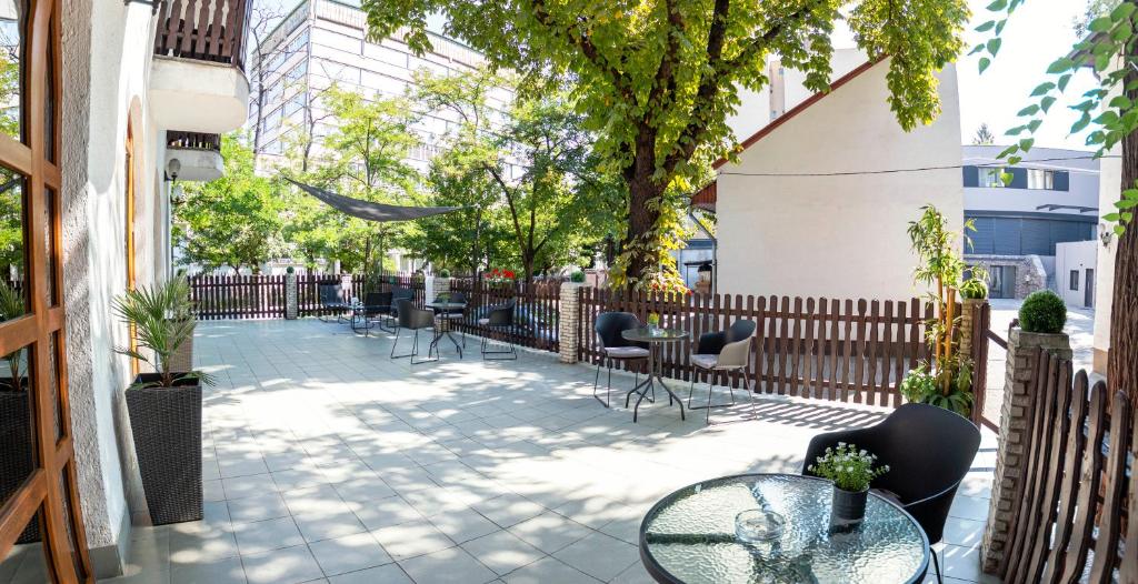 a patio with tables and chairs and a fence at Richter Pansion in Budapest