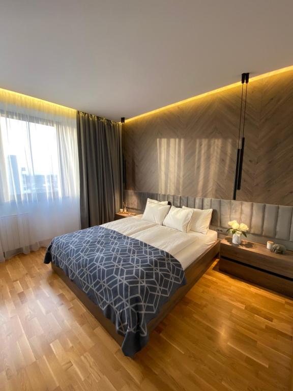 a bedroom with a large bed and a large window at DOM Boutique Apartments PARK VIEW in Belgrade