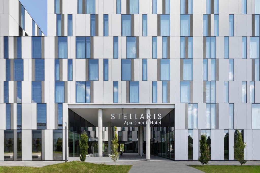 um edifício de escritórios com um sinal em frente em Stellaris Apartment Hotel em Garching bei München