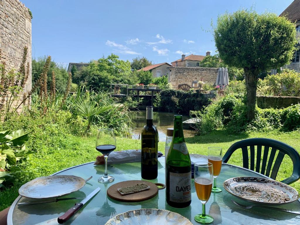a table with two bottles of wine and glasses at Rue des Douves in Verteuil-sur-Charente