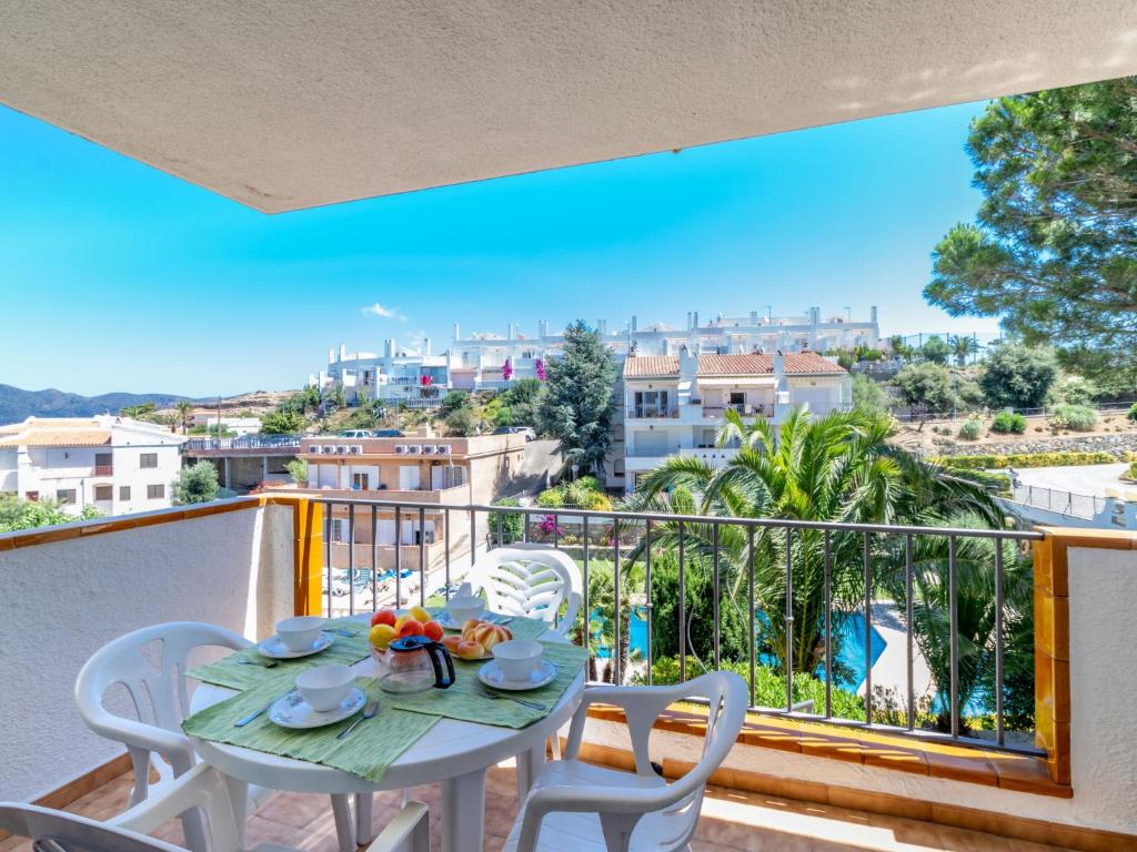 una mesa y sillas en un balcón con vistas en Apartment Els Jardins III by Interhome en Rosas