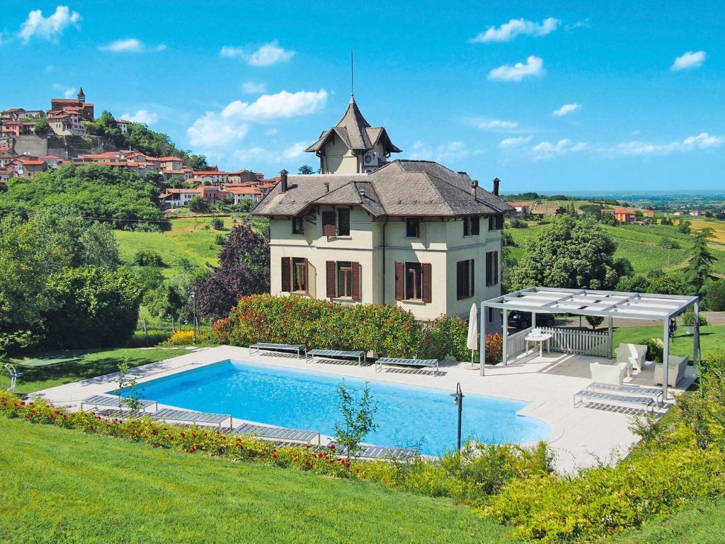a large house with a swimming pool in front of it at Holiday Home Villa Sarezzano by Interhome in Sarezzano