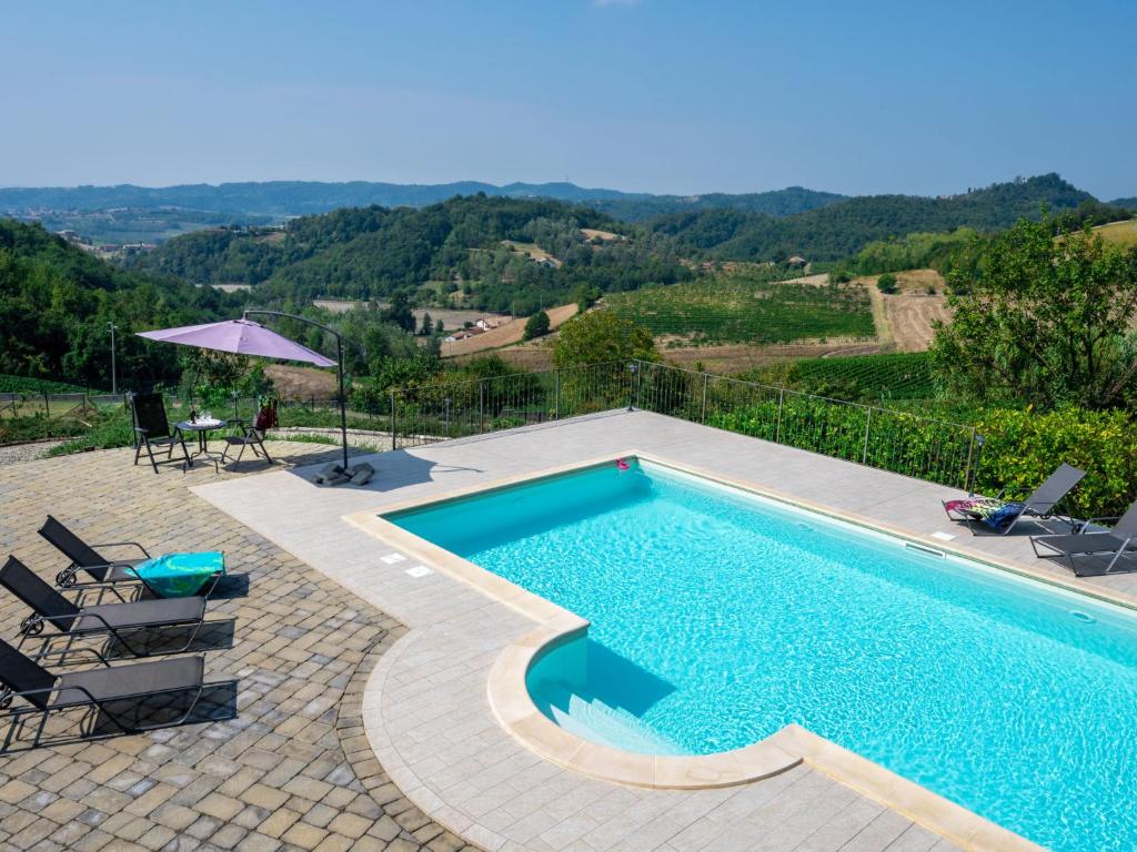 basen z krzesłami i parasolem w obiekcie Holiday Home Casa Chiara - SIC400 by Interhome w mieście Serralunga di Crea