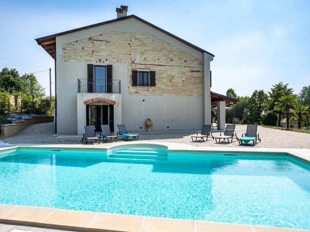 eine Villa mit einem Pool vor einem Haus in der Unterkunft Holiday Home Casa Chiara - SIC400 by Interhome in Serralunga di Crea