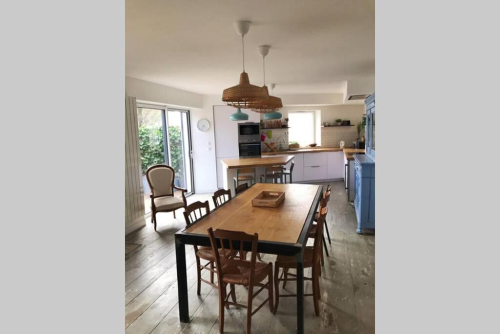 a kitchen and dining room with a table and chairs at Maison proche centre ville in La Rochelle
