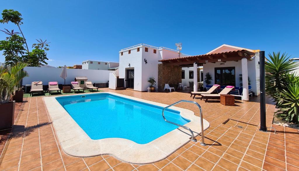 uma piscina em frente a uma casa em Beautiful Villa Grace, Caleta de Fuste em Caleta De Fuste