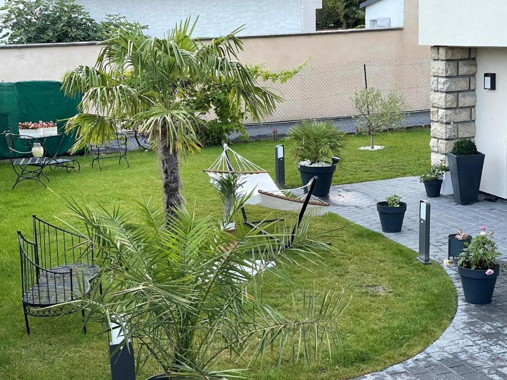 - un jardin avec un hamac et un palmier dans l'établissement Independent house with garden - Airport CDG and Exposition center of Villepinte, à Sevran