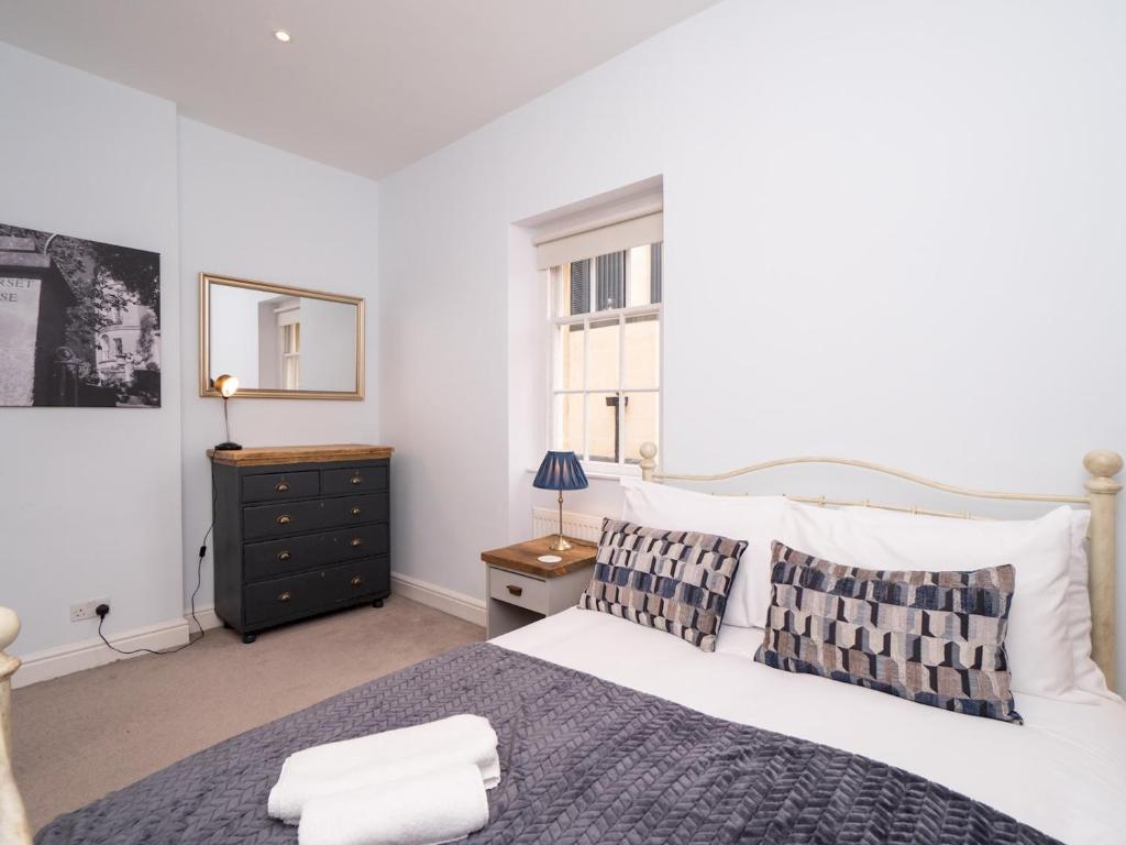 a bedroom with a large white bed and a window at Pass the Keys Centrally located 3 bed Townhouse with garden in Bath