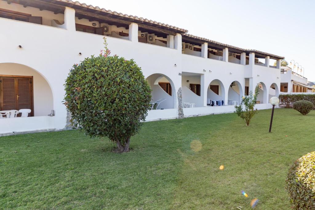 a large white building with a green yard at Il Complesso Saraceno in Torre delle Stelle