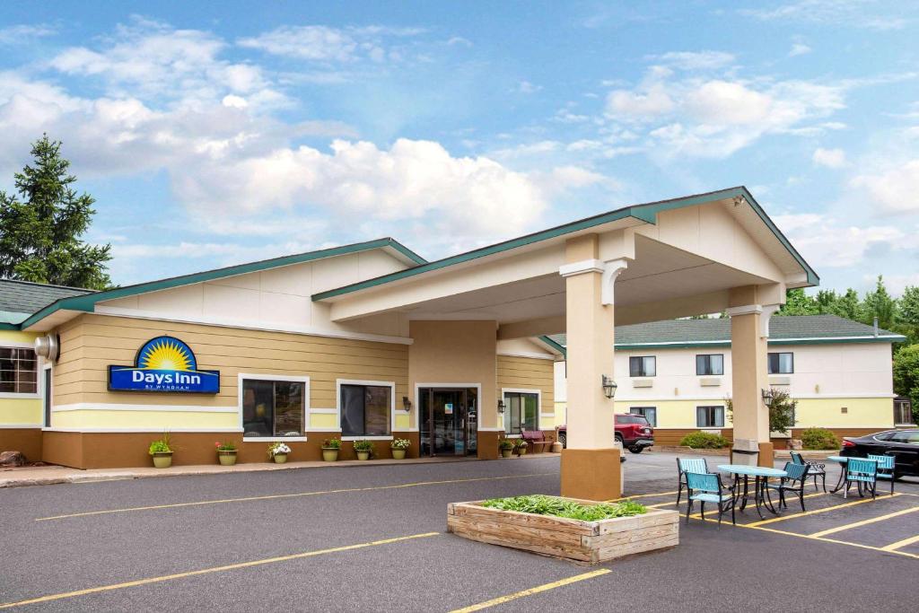 a front view of a hotel with a parking lot at Days Inn by Wyndham Marquette in Marquette