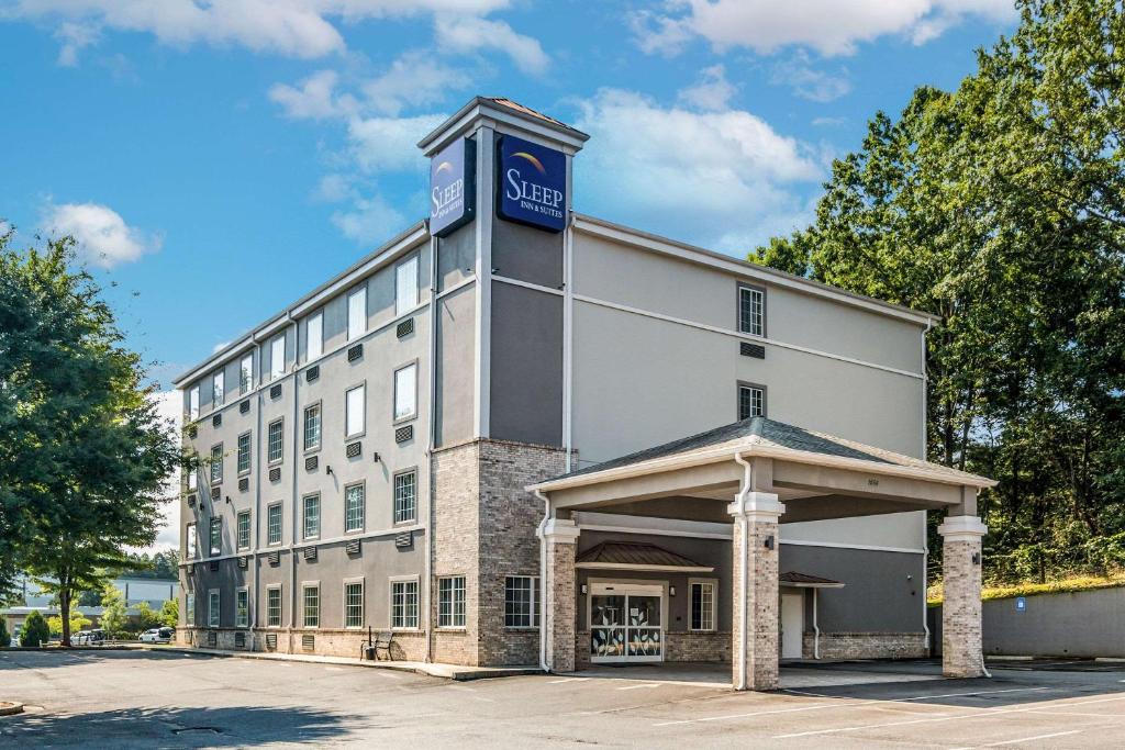 ein großes weißes Gebäude mit einem Schild darüber in der Unterkunft Sleep Inn & Suites at Kennesaw State University in Kennesaw