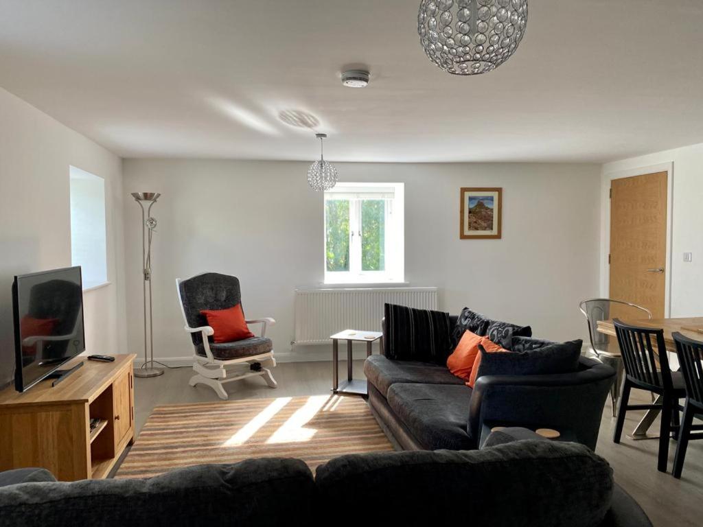29 Malthouse Alnwick Holiday Apartment في ألنويك: غرفة معيشة مع أريكة وتلفزيون