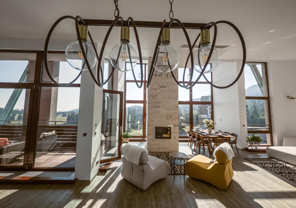 una sala de estar con una gran lámpara de araña en Penthouse Poiana Brașov B44, en Poiana Brasov