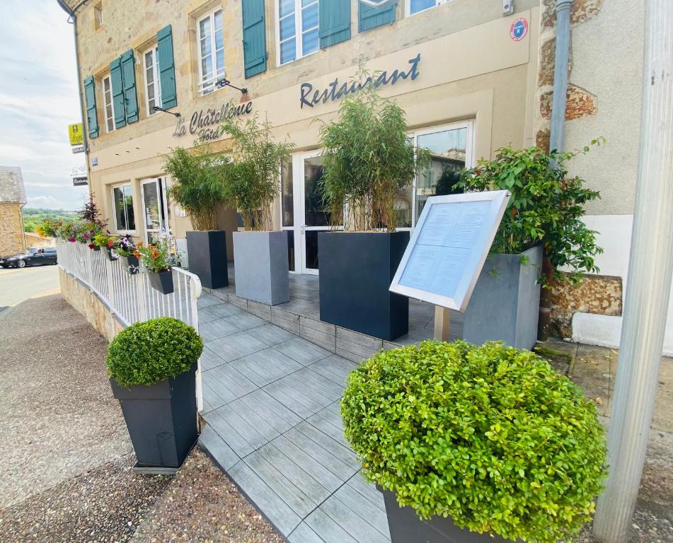 a store with potted plants in front of a building at Logis Hôtel La Châtellenie in Availles-Limouzine