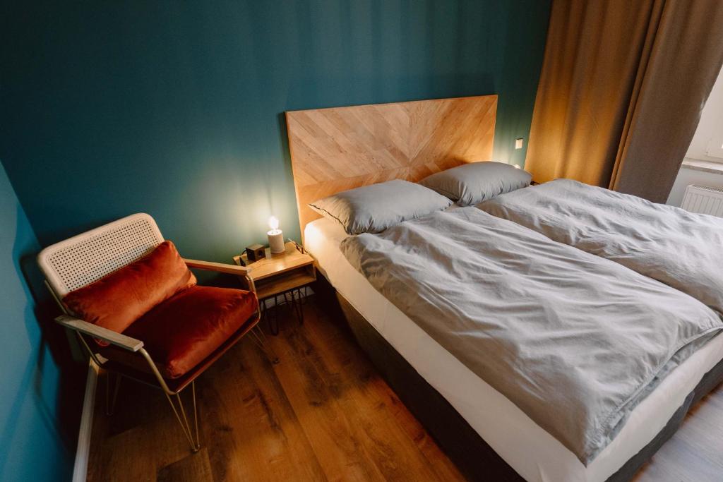 1 dormitorio con 1 cama grande y 1 silla en Schlafladen Hildesheim Hotel & Hostel, en Hildesheim