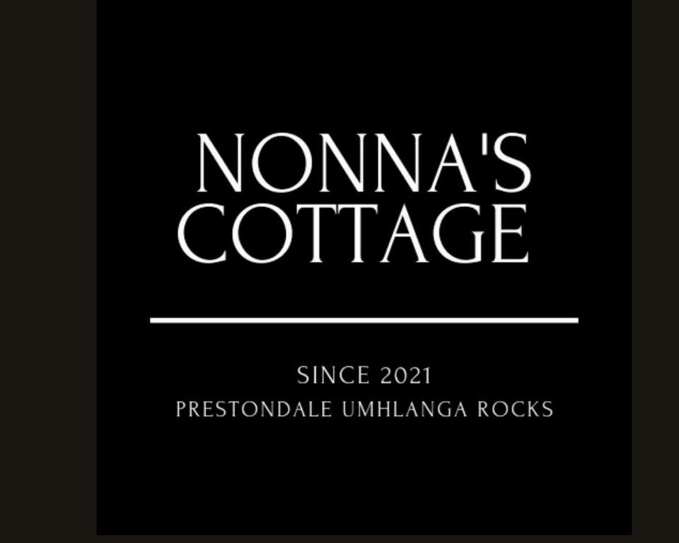 a sign that reads monamines cottage with a black background at Nonna's Cottage in Durban